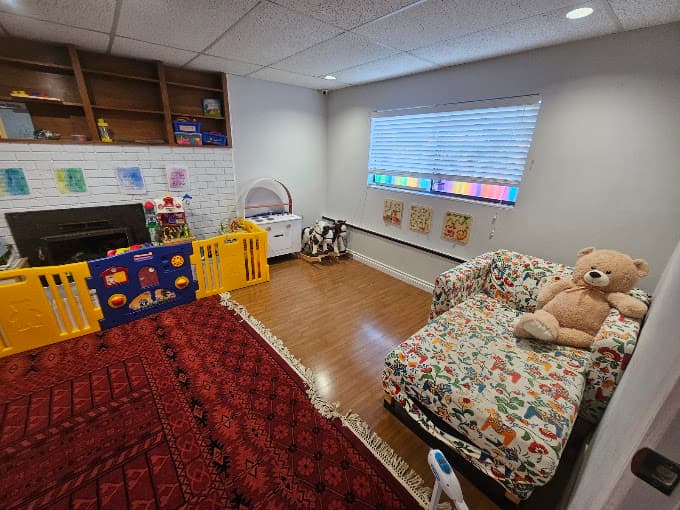 Playroom with a play mat, toys, and a reading nook